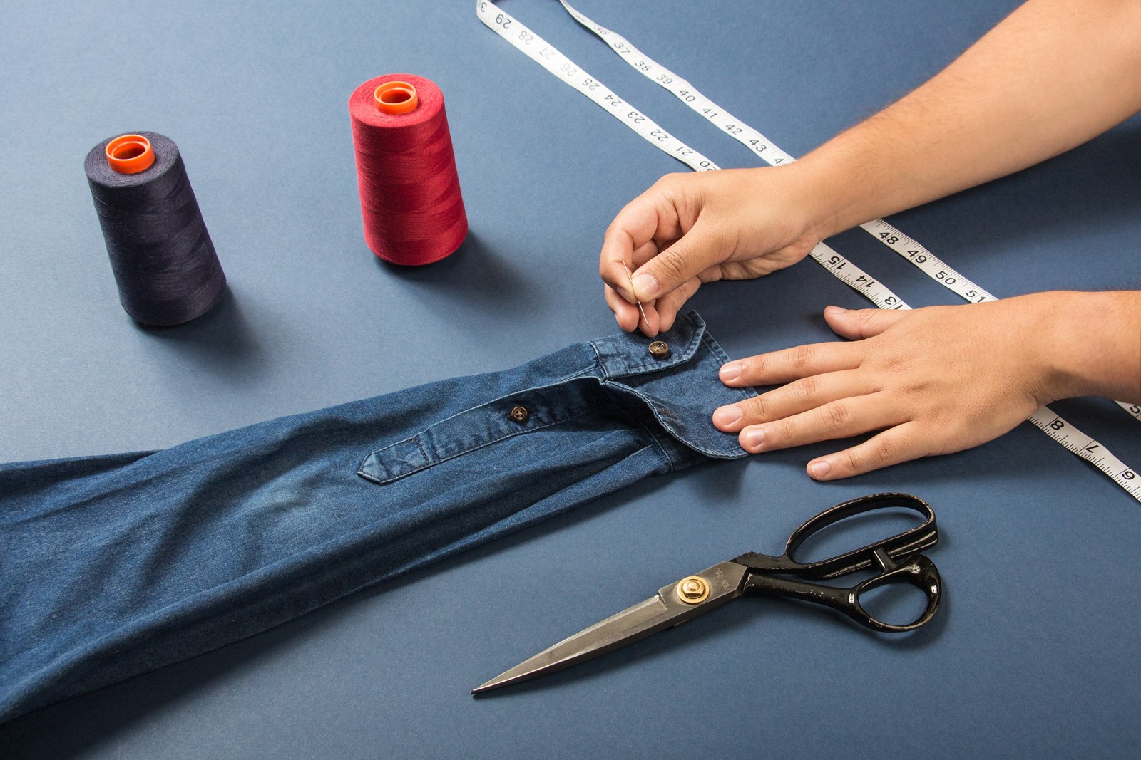 Hands carefully measuring a garment on the original shop website